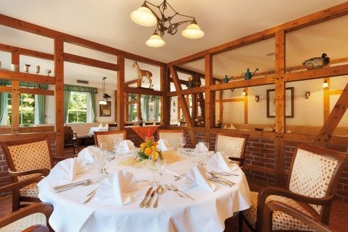 Rustikales Restaurant mit Holzdekor, rundem Tisch und sorgfältig gedecktem Geschirr.